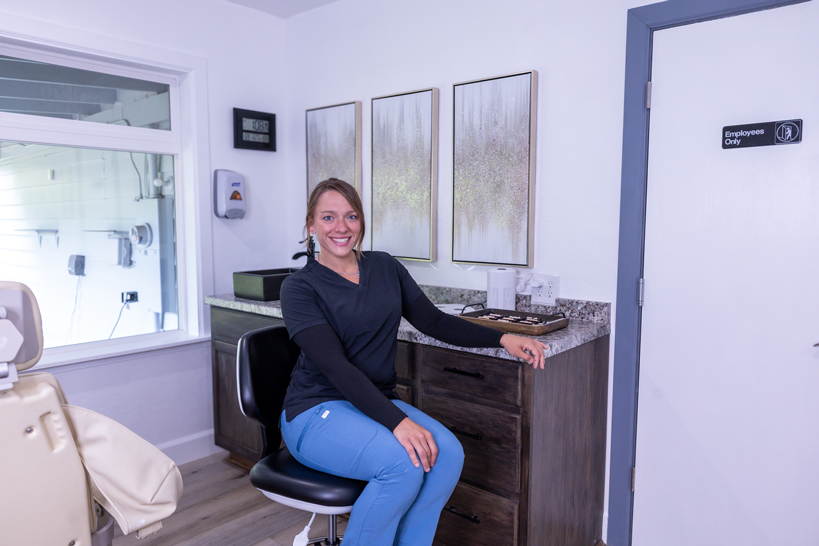 Denturist in treatment room, smiling.
