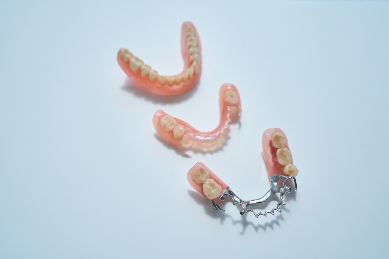 Various dental prosthetics on display. These are acrylic and cast metal denture options.